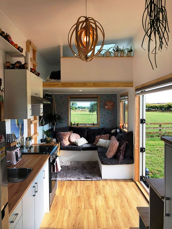 Inside a Tiny House showing living room, kitchen and pendent lamp