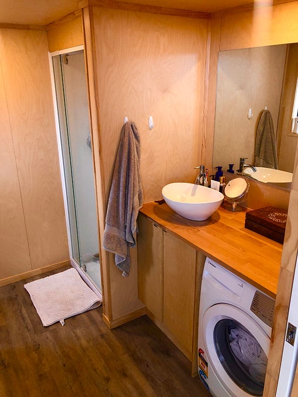 ply bathroom in a Tiny Home showing counter top sink and washing machine