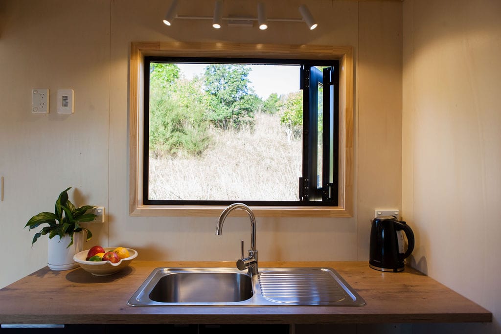 The Kitchen showing the Foldback BiFold window in the Everest Tiny Home by Fox Cabins, Raglan.