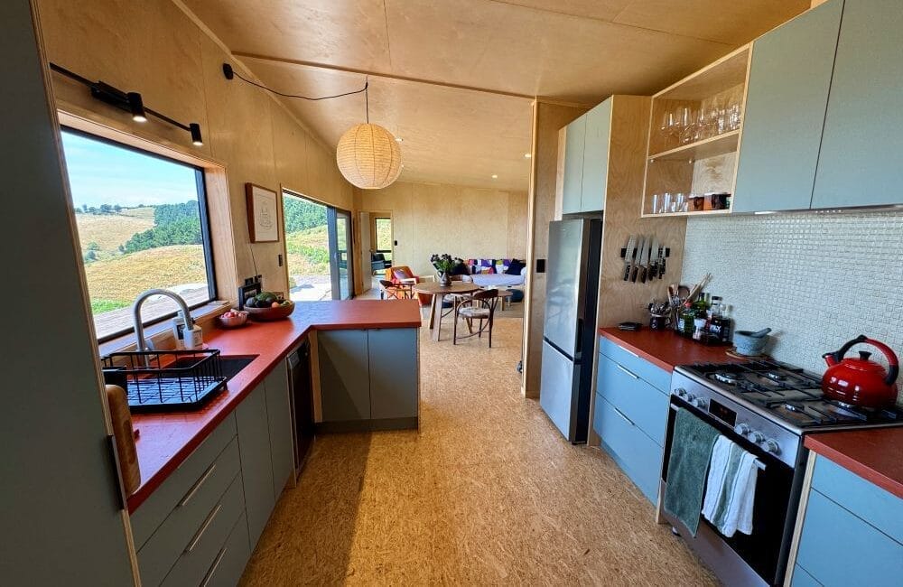 The Kitchen of The Bach Two Bedroom Modular Home by Fox Cabins showing custom cabinets and concrete countertop